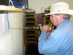 Den drilling the pilot hole through the wall